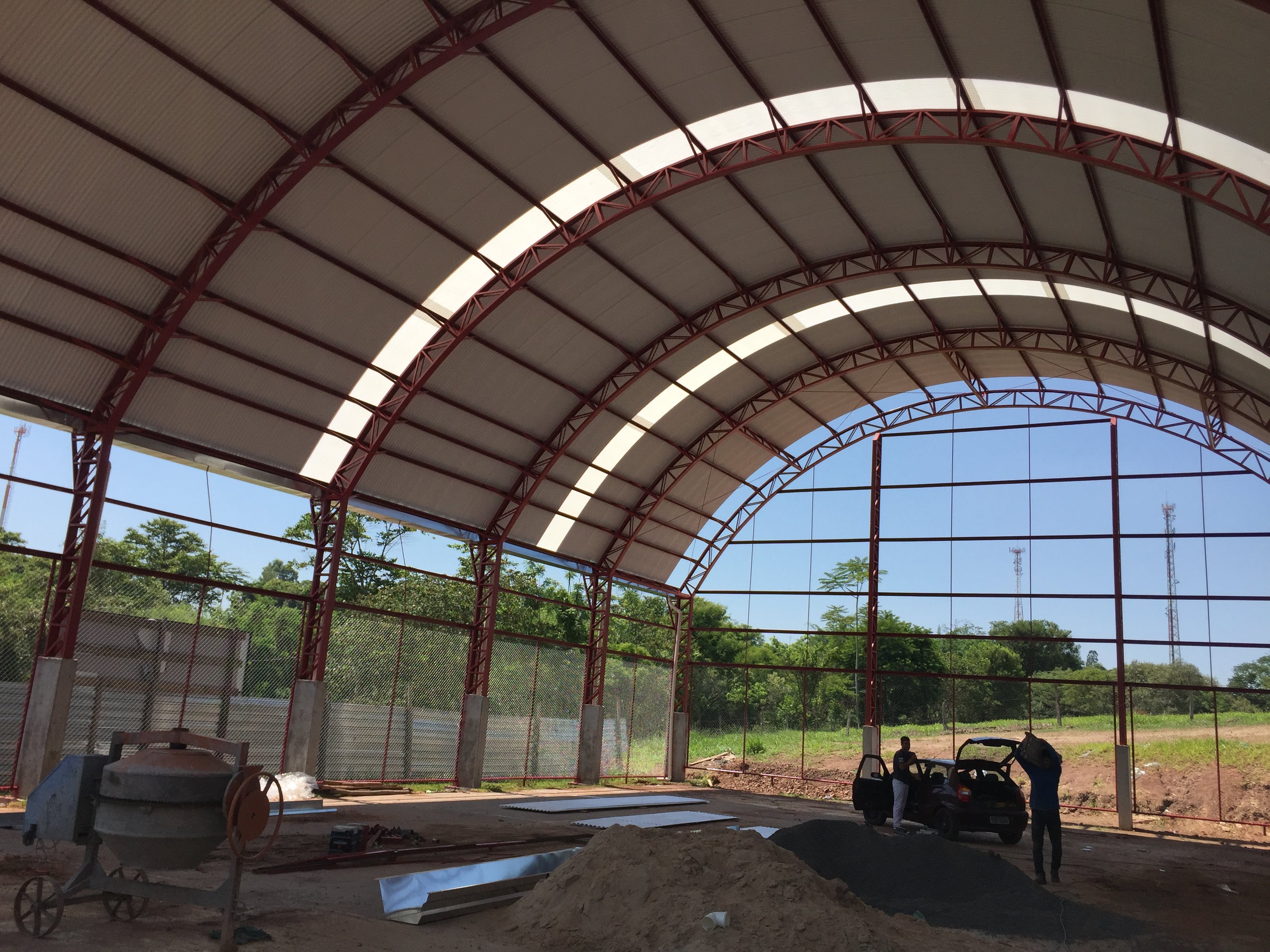 Estrutura metálica para quadra poliesportiva com 600m². Colunas metálicas treliçadas, telha galvalume ondulada.
